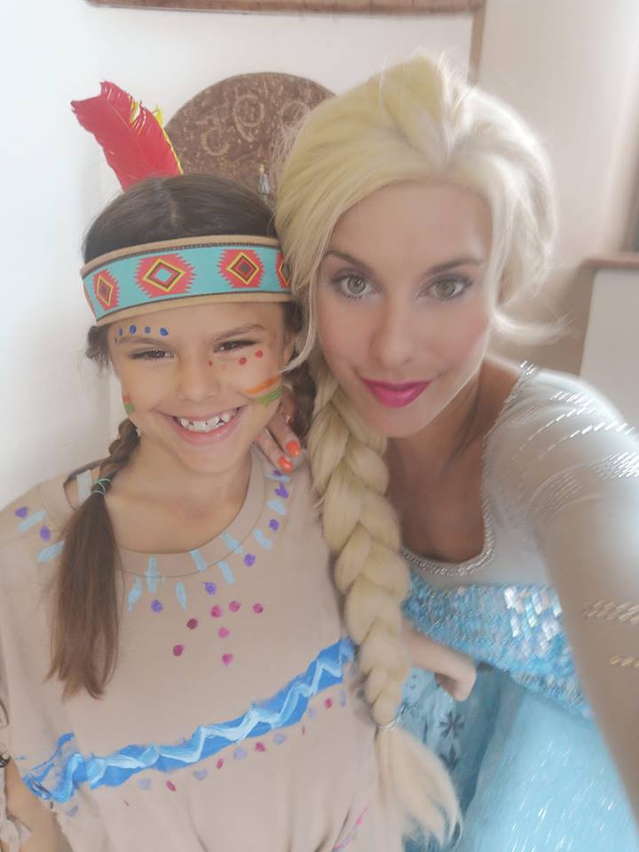 Die Elsa Eiskönigin mit einem Mädchen, das als Pocahontas verkleidet ist.
