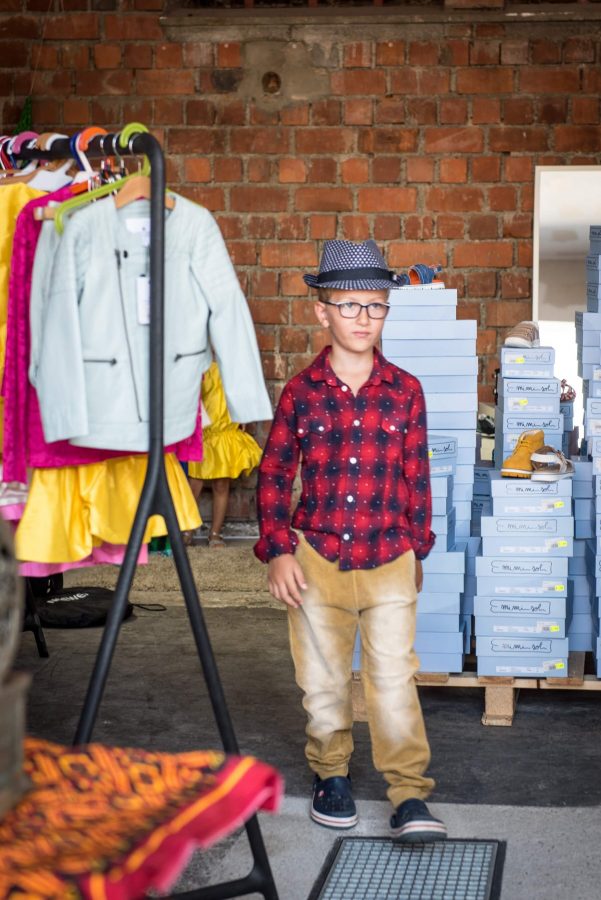 Junge zeigt Kleidung für Flohmarkt